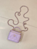 Chanel lavender quilted mini bag with top handle, long chain strap, and zip closure