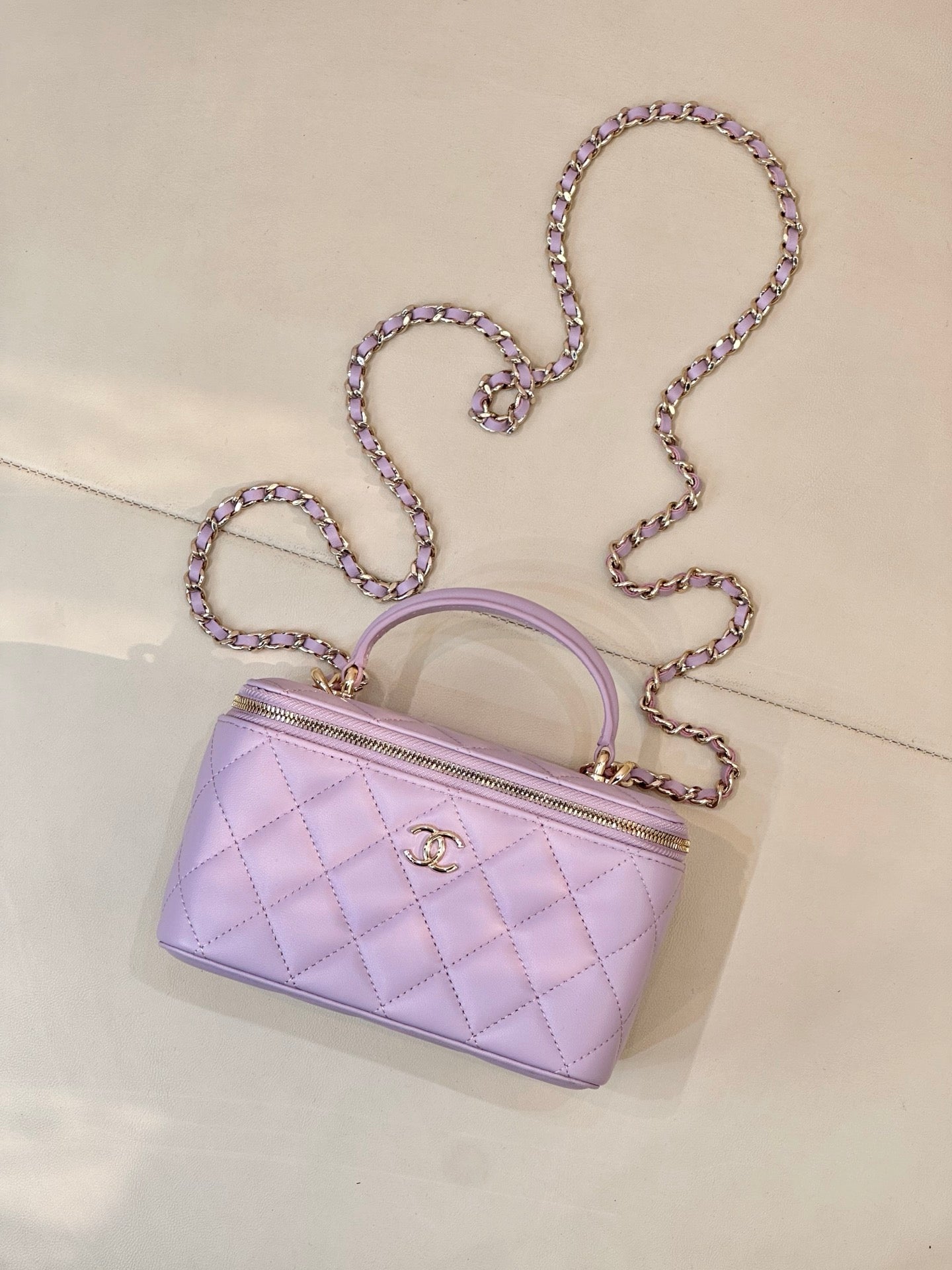 Lavender Chanel quilted bag with gold-tone zipper, CC clasp, top handle and chain strap