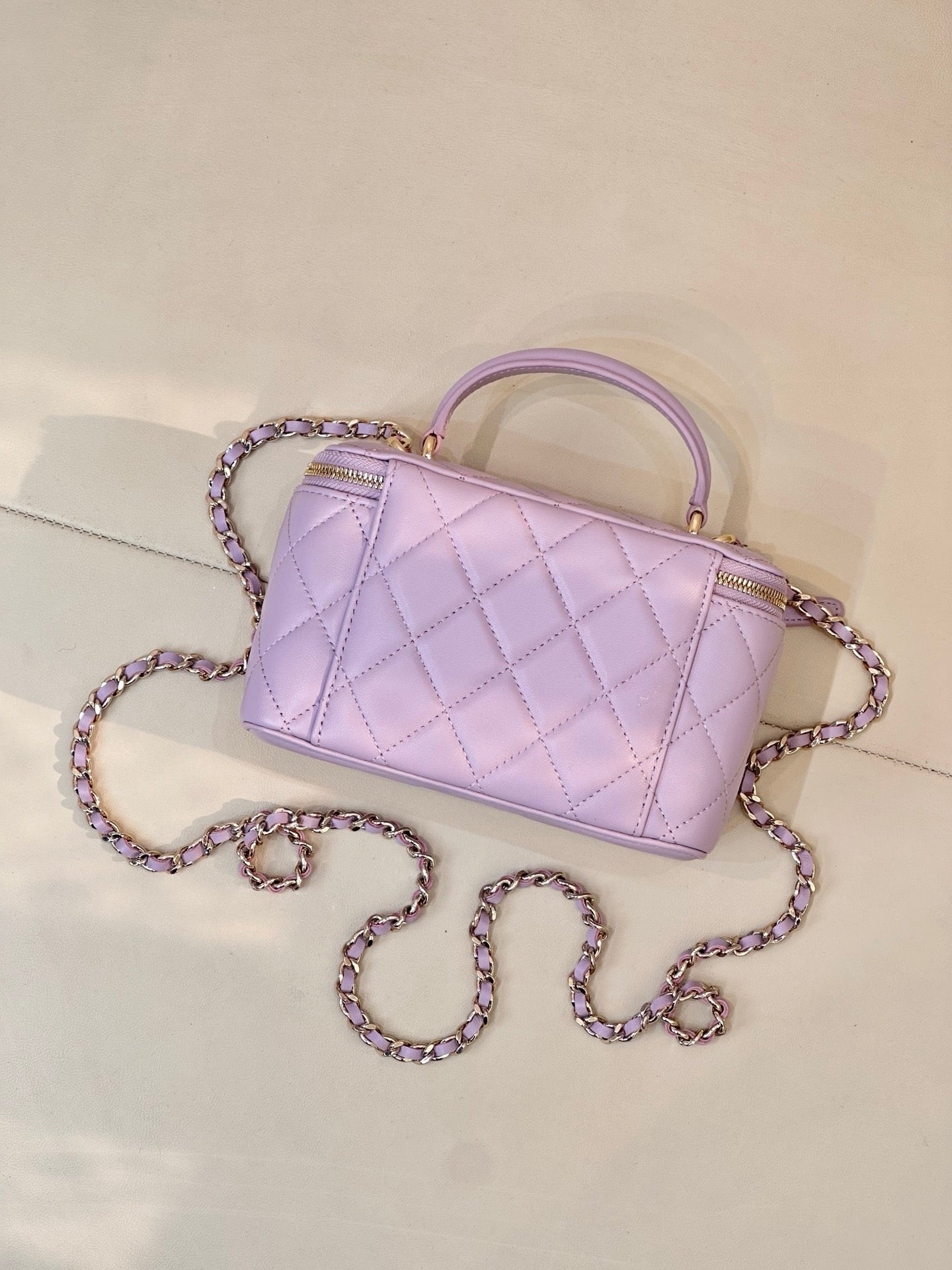 Lavender Chanel quilted handbag with gold-tone zipper, CC clasp and long chain strap
