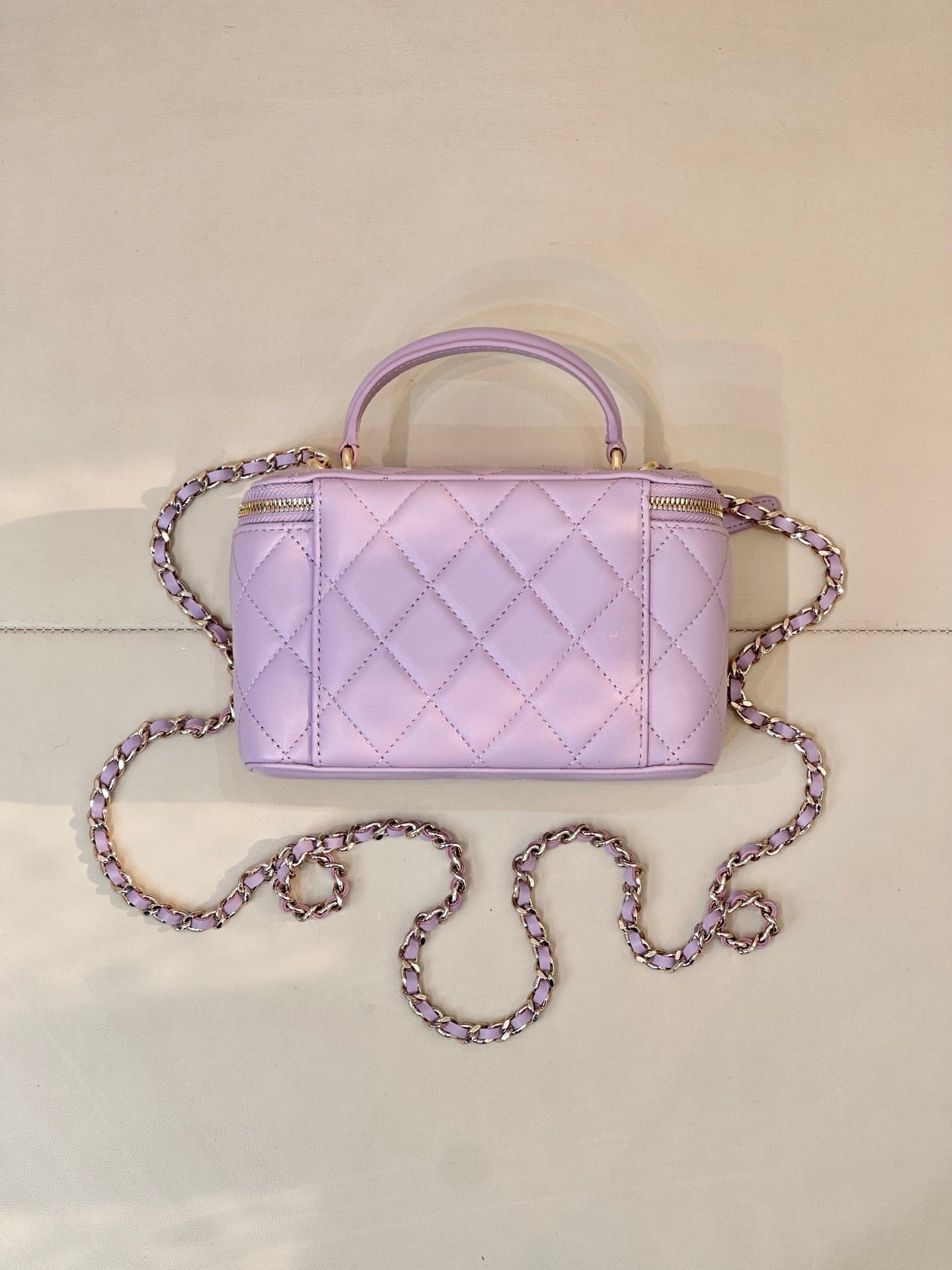 Lavender Chanel quilted handbag with gold-tone zipper, CC clasp, top handle and chain strap
