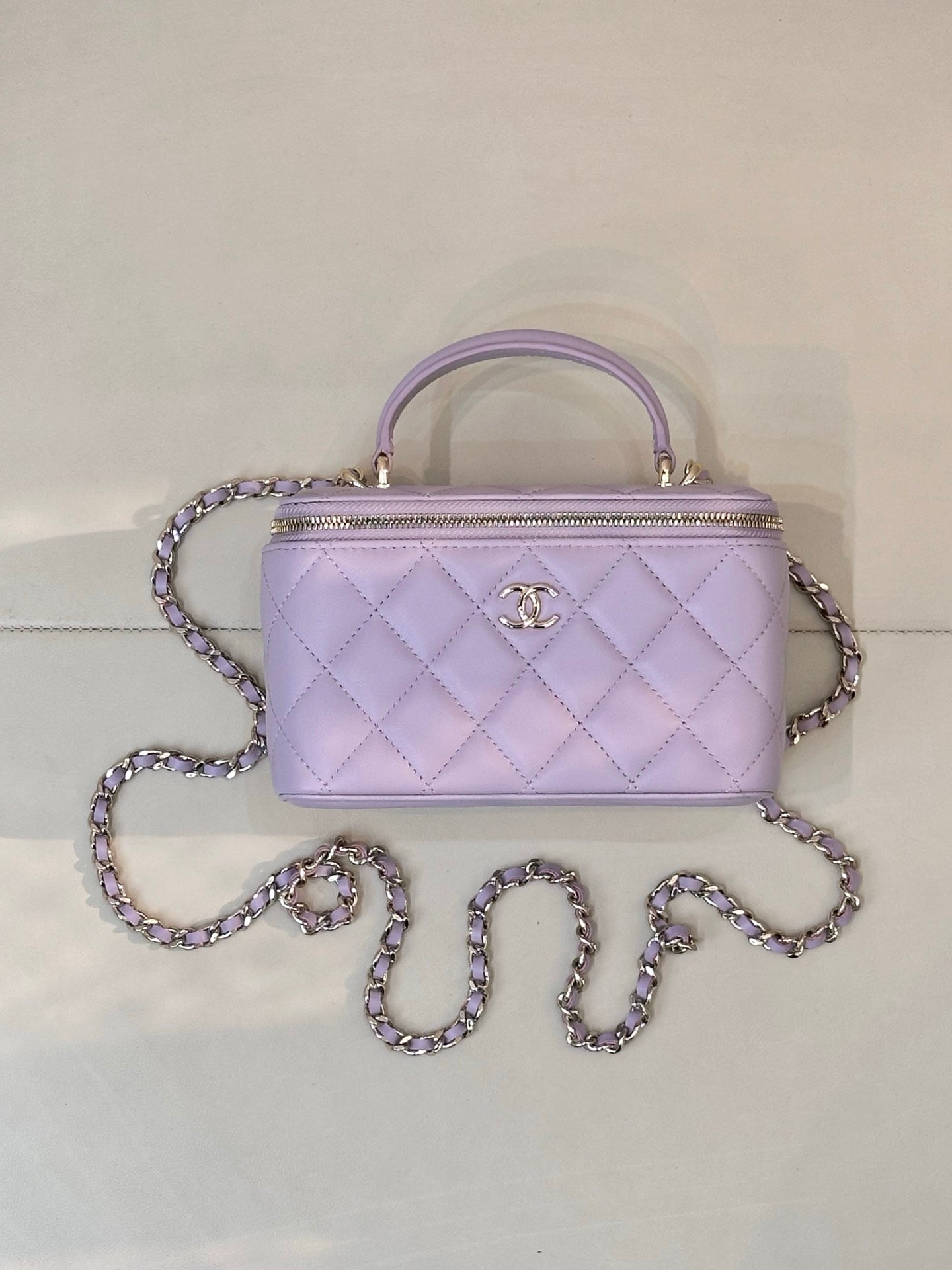 Lavender Chanel quilted handbag with gold-tone zipper, CC clasp, top handle and chain strap