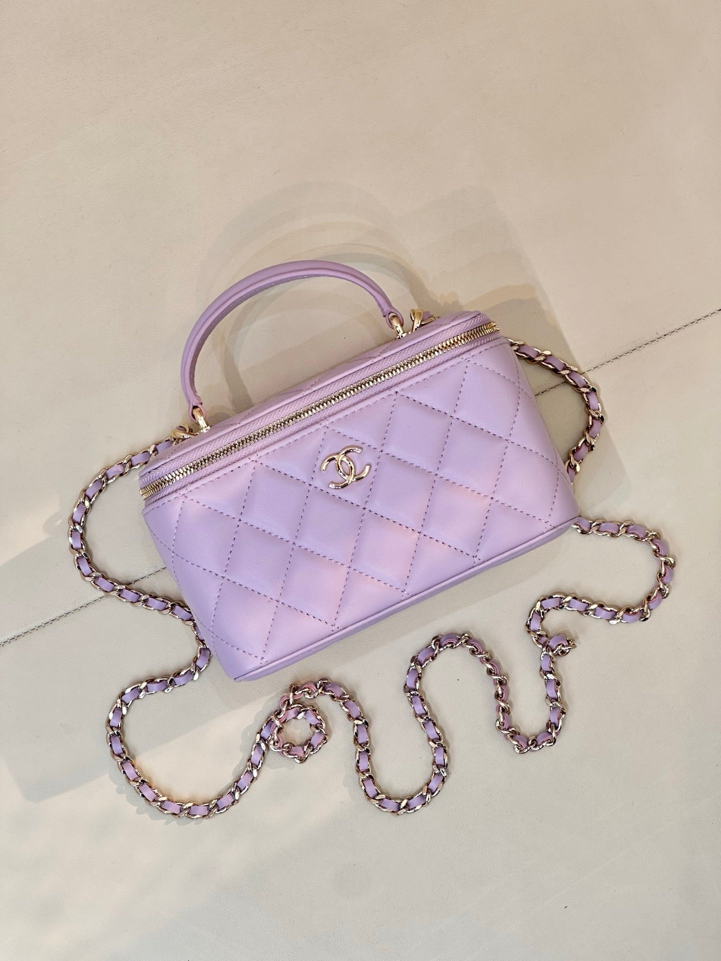 Lavender Chanel quilted handbag with gold-tone zipper, CC clasp, top handle and chain strap