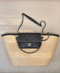 Beige woven tote bag with black trim, chain handles, and quilted flap mini bag
