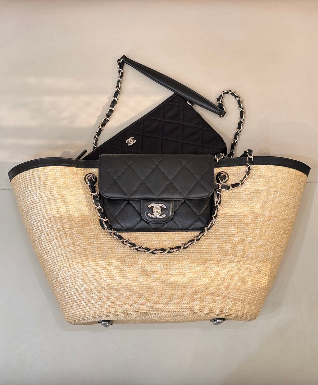Beige woven tote with black trim, chain handles, and black quilted flap bag