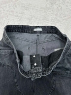 Denim pants waistband detail with inner label, snap closure, and stitched seams