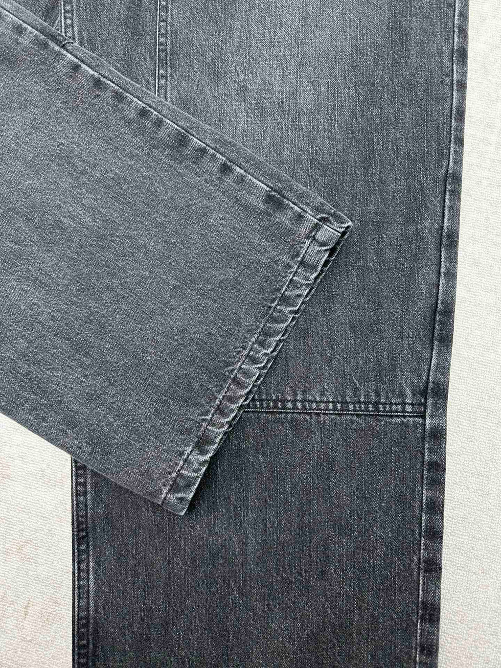 Denim cuff and front leg seam detail with visible stitching