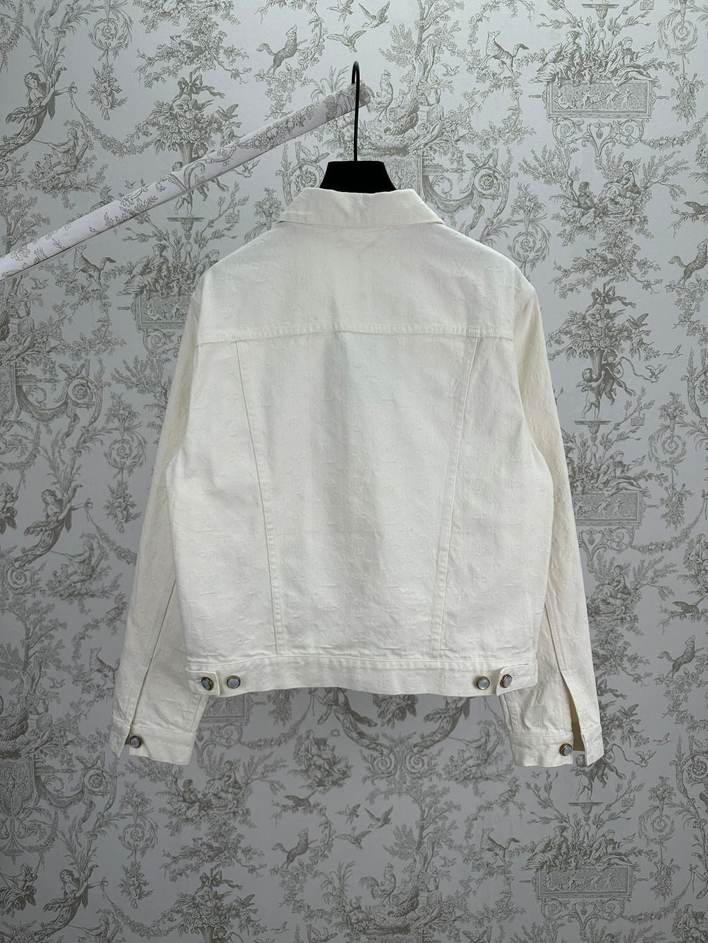 Long white jacket back view with buttoned hem and yoke seam