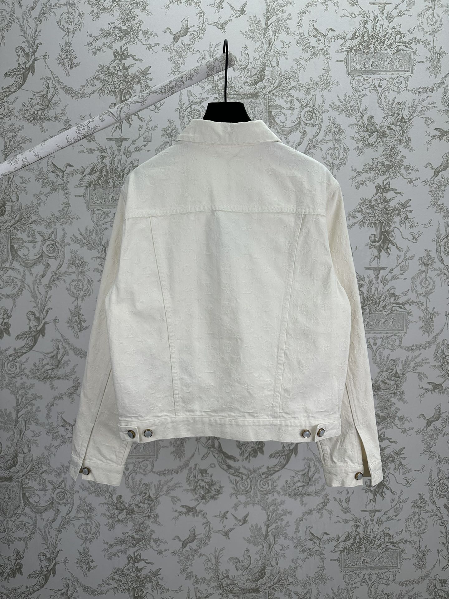 Long white jacket back view with buttoned hem and yoke seam