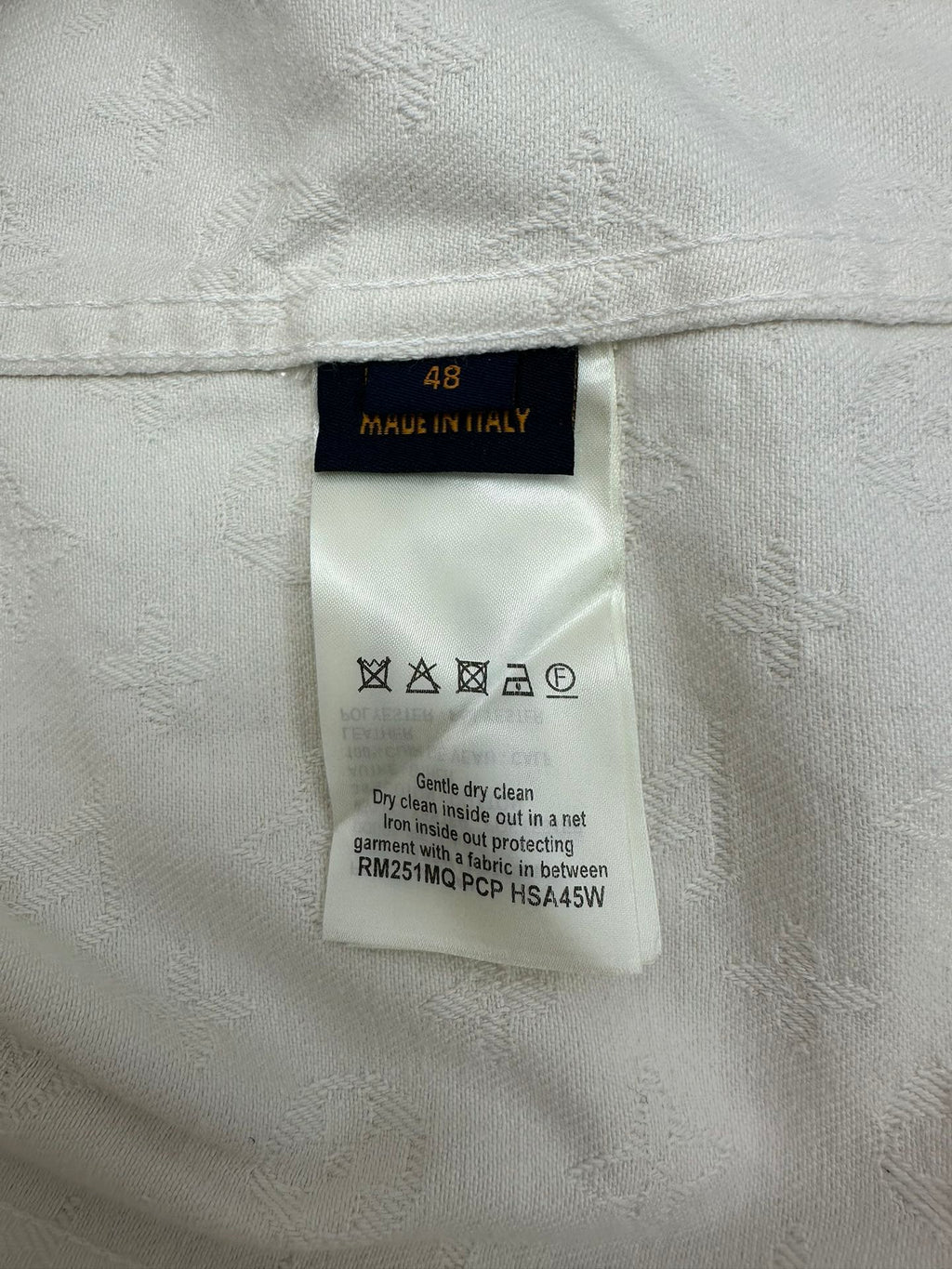 Long white jacket interior care label with size 48 and washing symbols