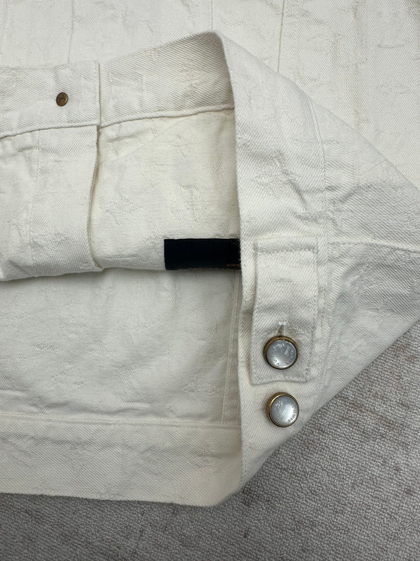 Long white jacket side button placket and shoulder yoke detail
