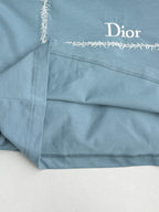 Light blue Dior T-shirt close-up of hem stitching and “Dior” label