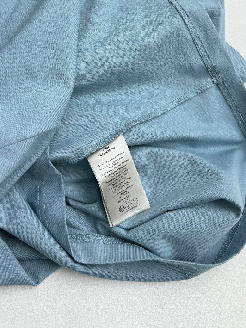 Light blue Dior T-shirt interior neck label on folded fabric