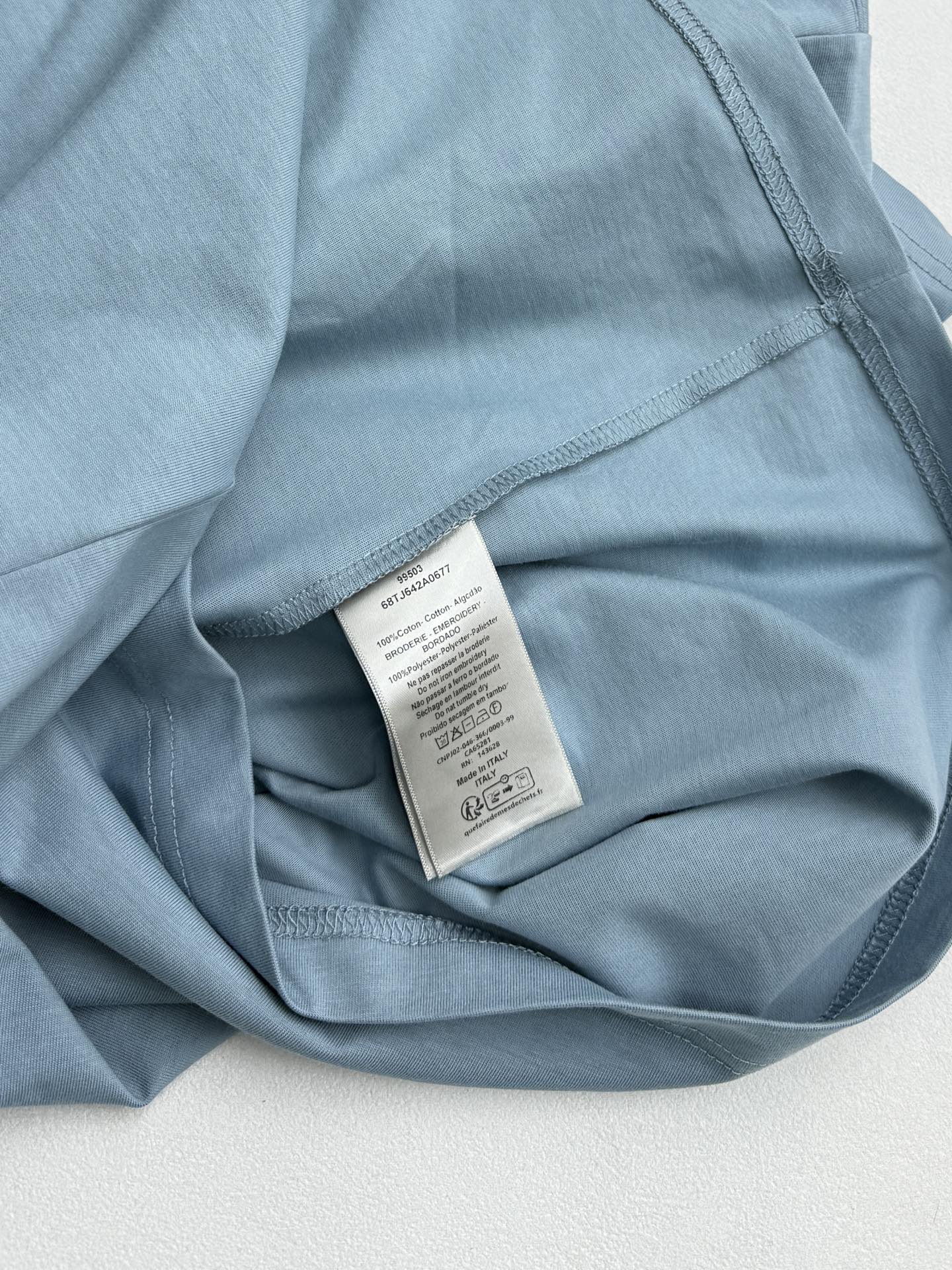 Light blue Dior T-shirt interior neck label on folded fabric