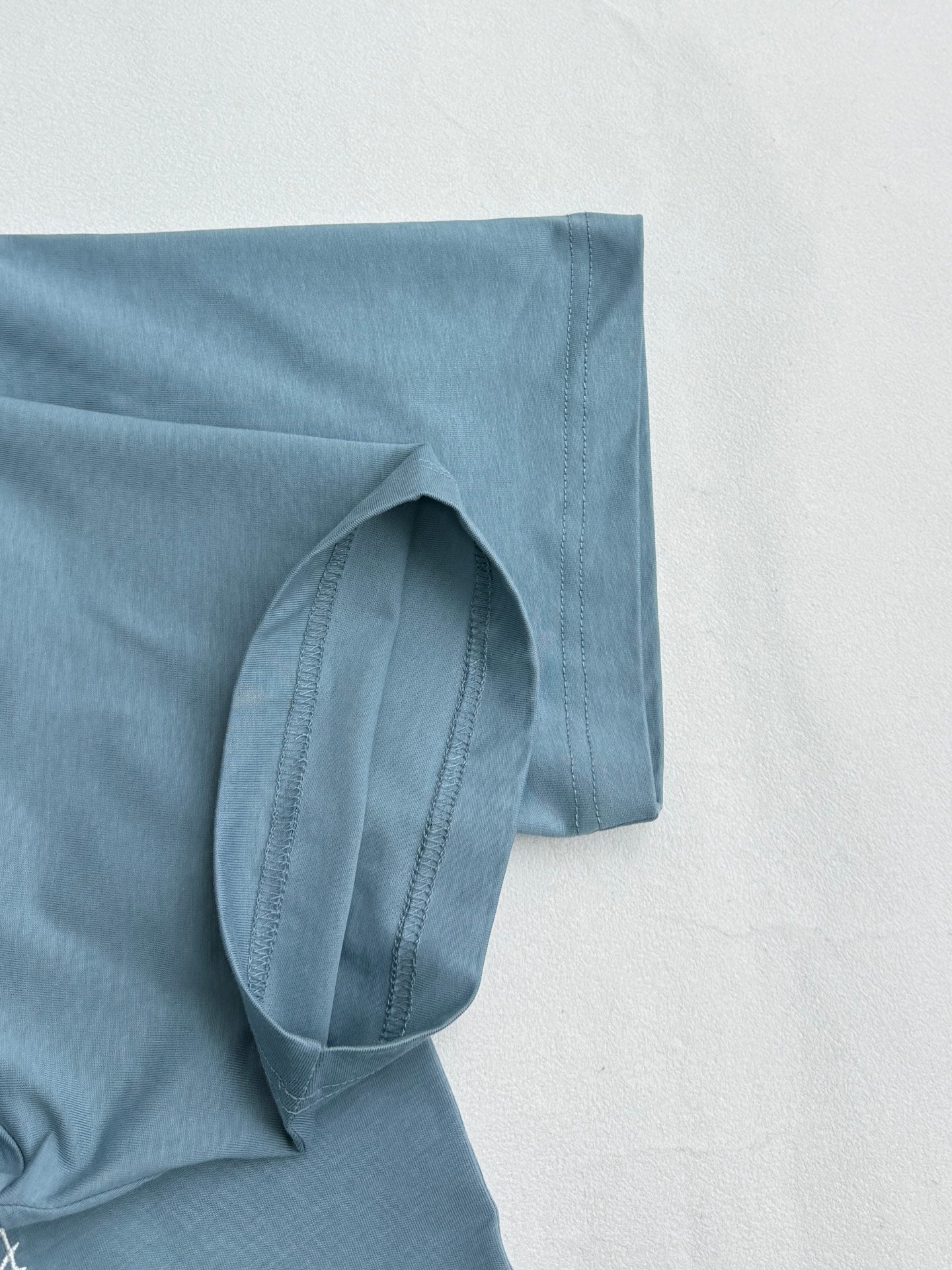 Light blue Dior T-shirt sleeve and side seam detail