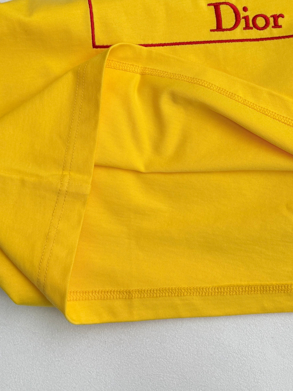 Yellow T-shirt hem and side seam stitching with Dior print