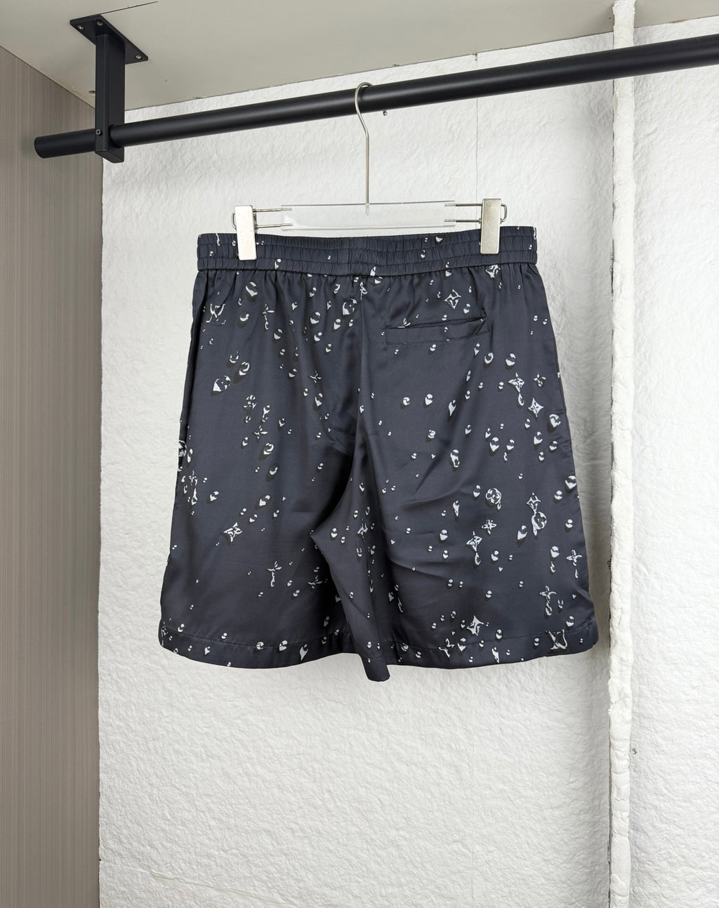 Black patterned shorts with elastic waistband and all-over white motif