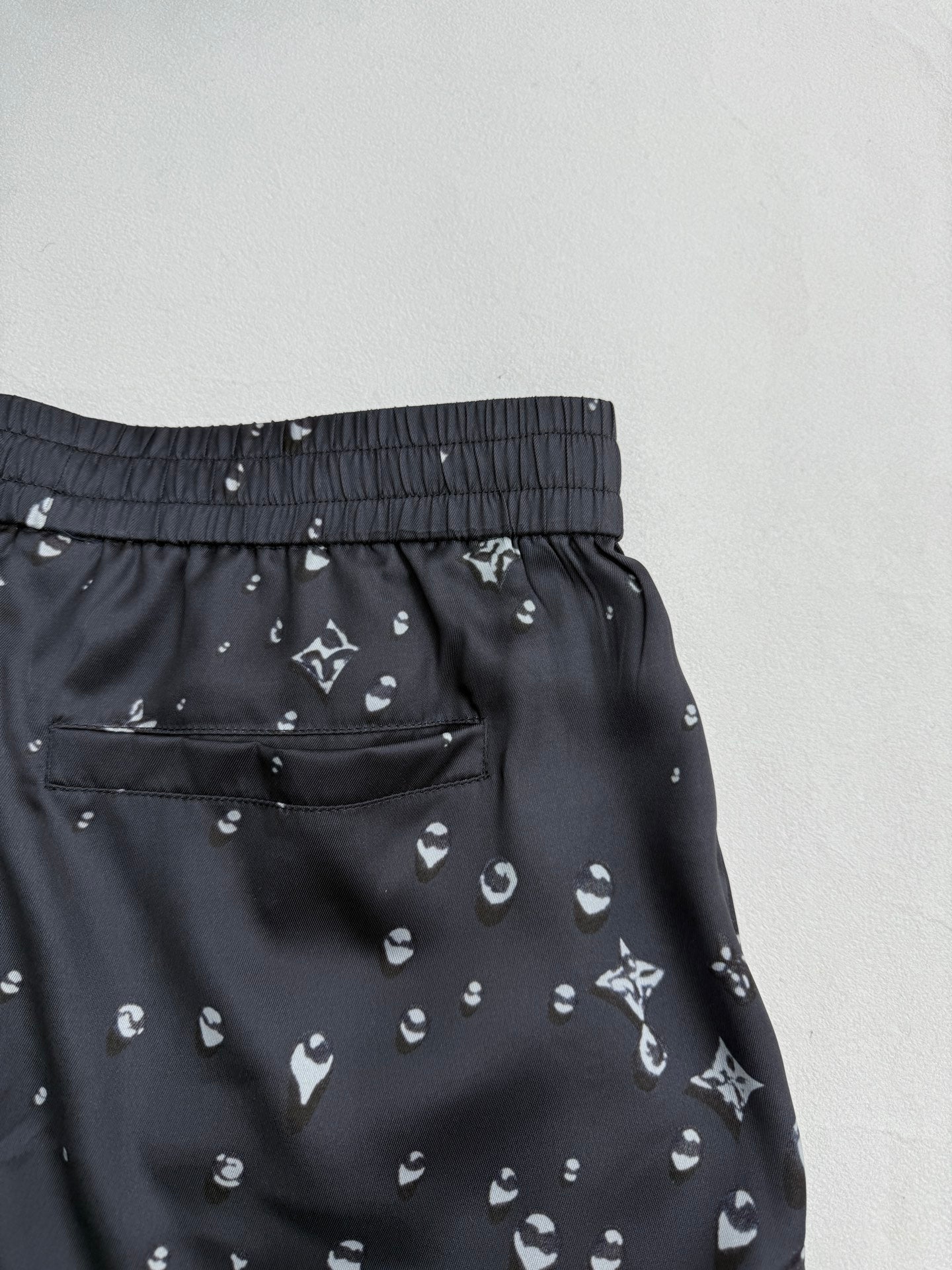 Black patterned shorts with patch pocket and elastic waistband