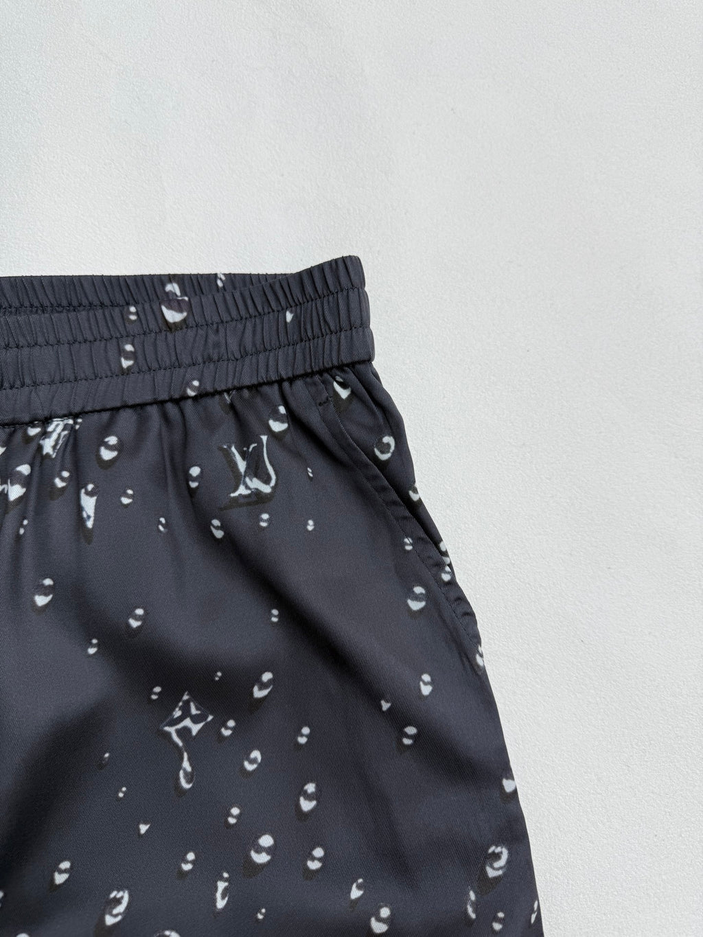 Black patterned shorts with elastic waistband and diagonal side seam detail