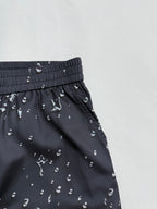 Black patterned shorts with elastic waistband and diagonal side seam detail