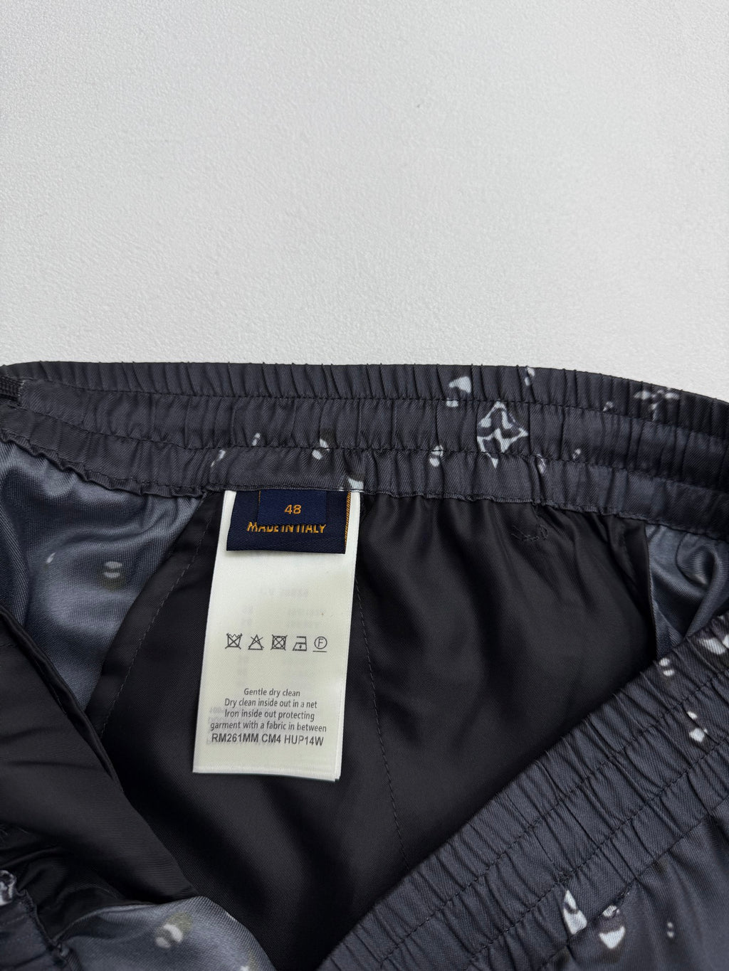 Black shorts inner pocket area with elastic waistband and white motif print
