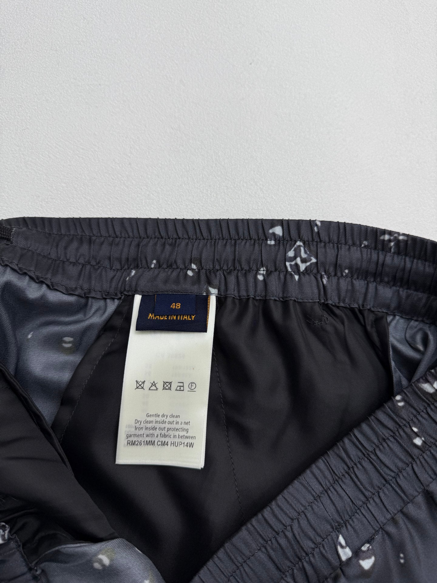 Black shorts inner pocket area with elastic waistband and white motif print