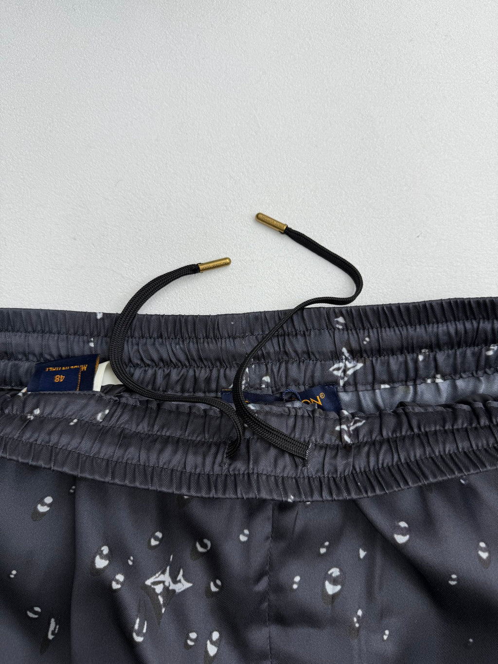 Black shorts waistband close-up with drawstring and inner fabric label