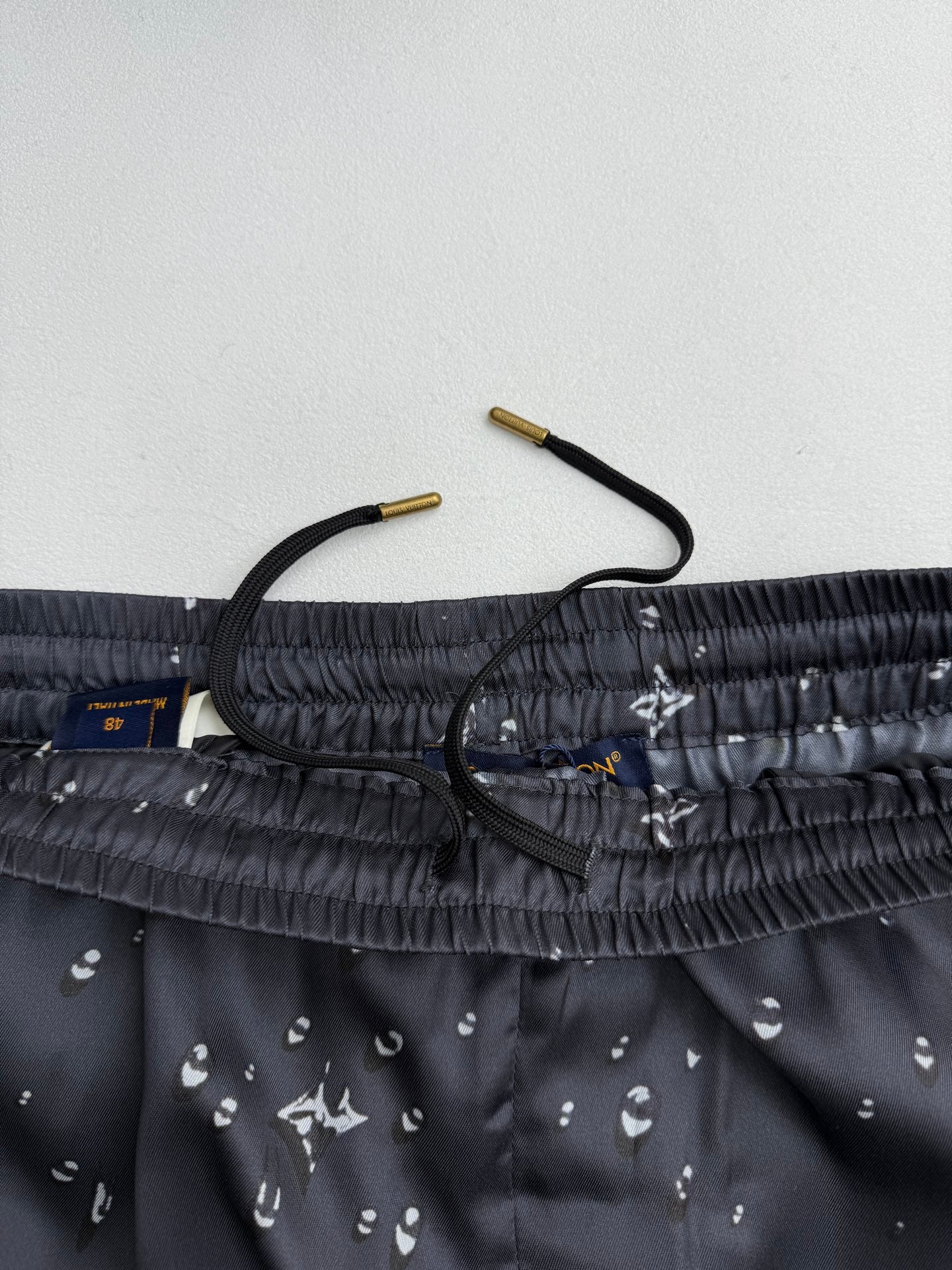 Black shorts waistband close-up with drawstring and inner fabric label