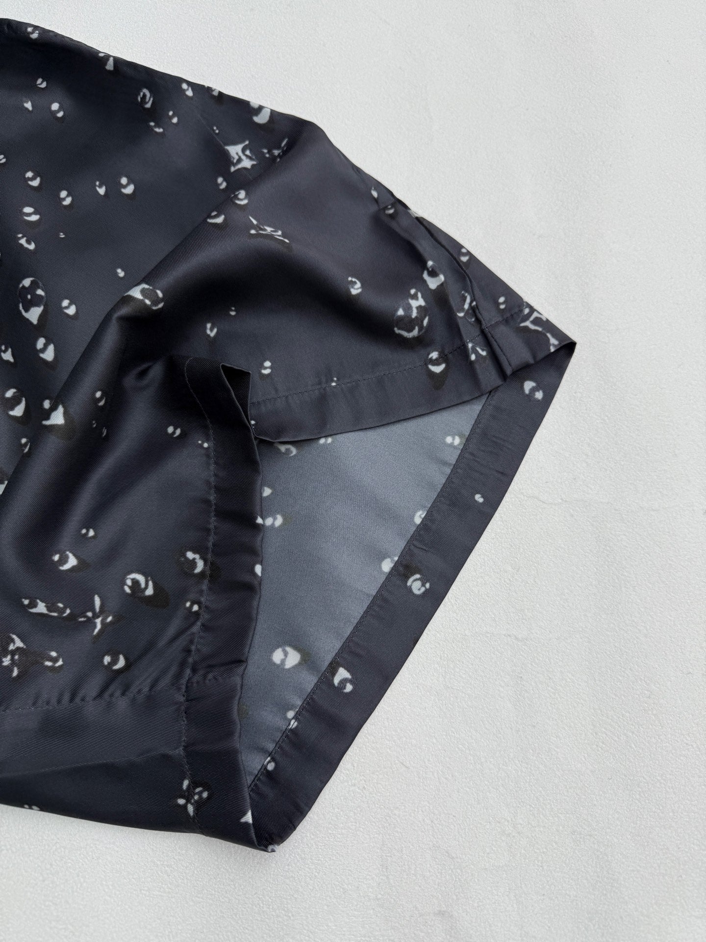 Black patterned shorts front with side seam and white motif print
