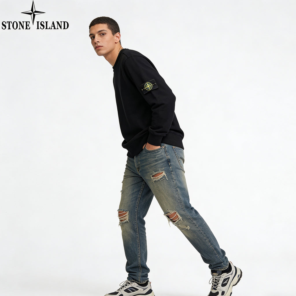 Stone Island black crewneck sweatshirt with sleeve patch, distressed blue jeans