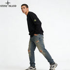 Stone Island black crewneck sweatshirt with sleeve patch, distressed blue jeans
