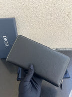 Dior small leather zip wallet bag back view in dark textured finish with gold zipper