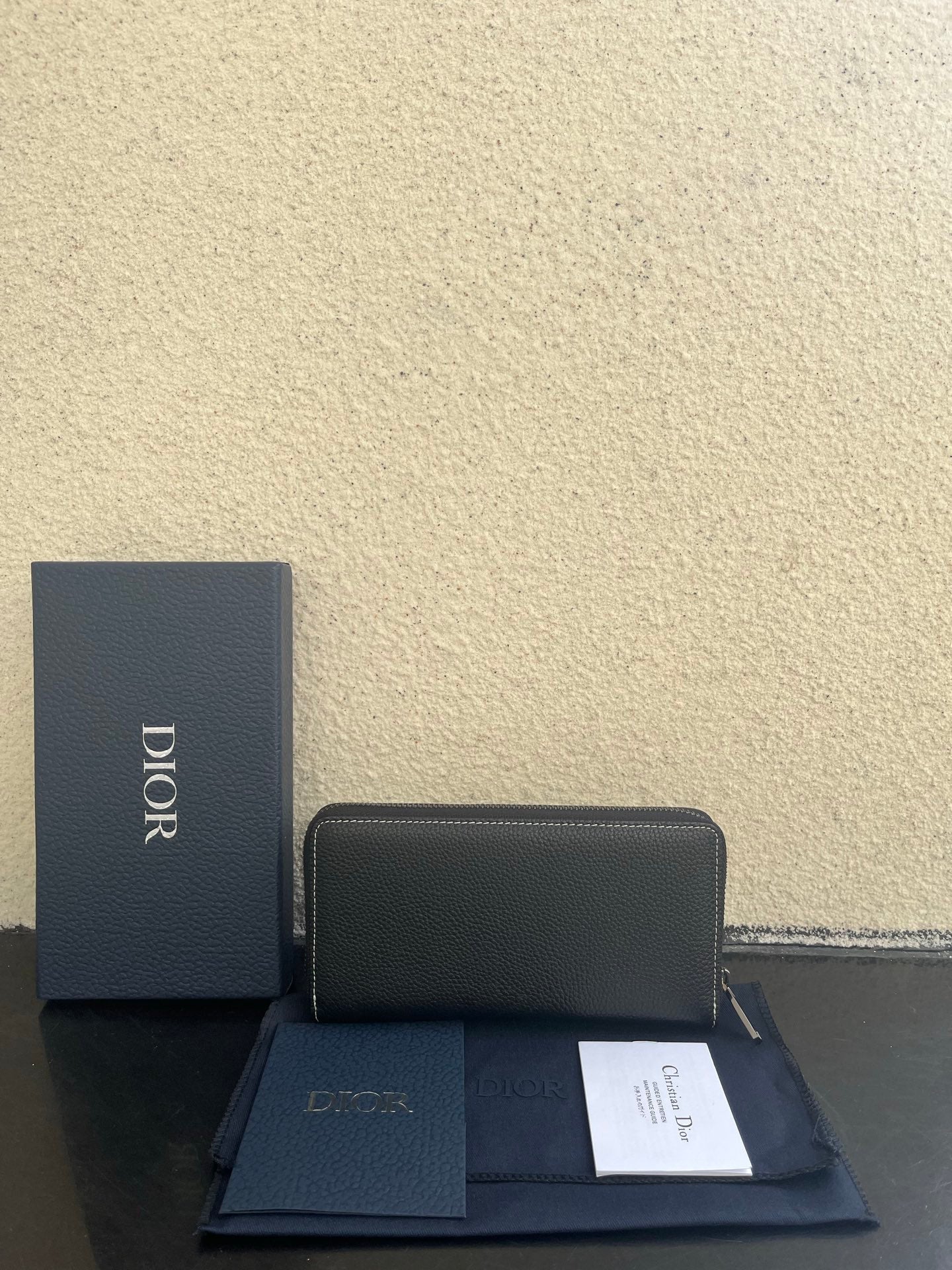 Dior small zip wallet bag in dark leather with stitched top seam and gold hardware