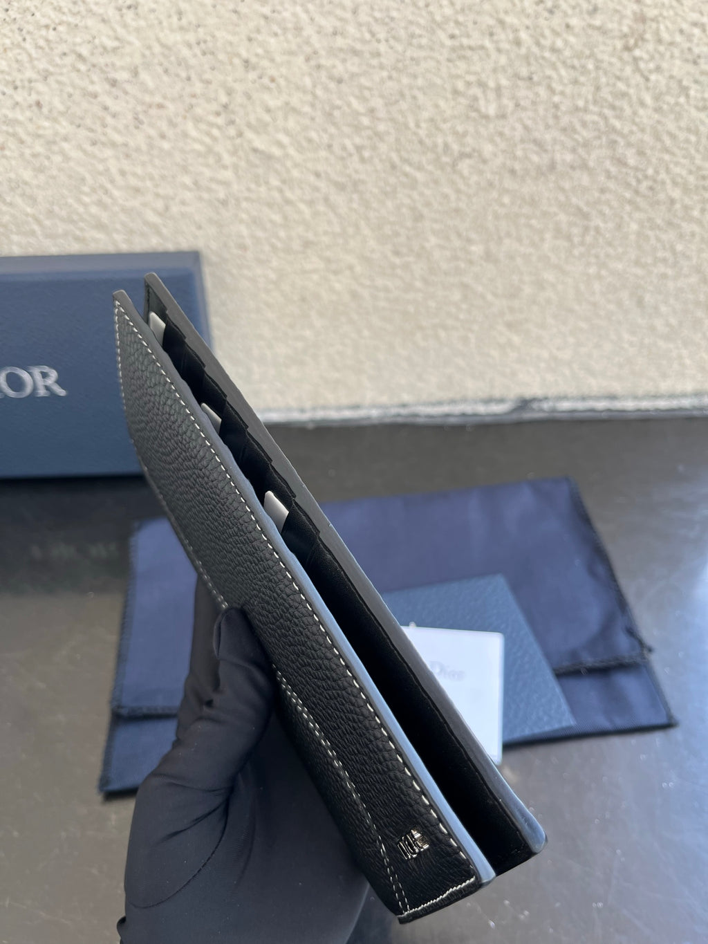 Small bag side profile in dark gray leather with interior card slots visible