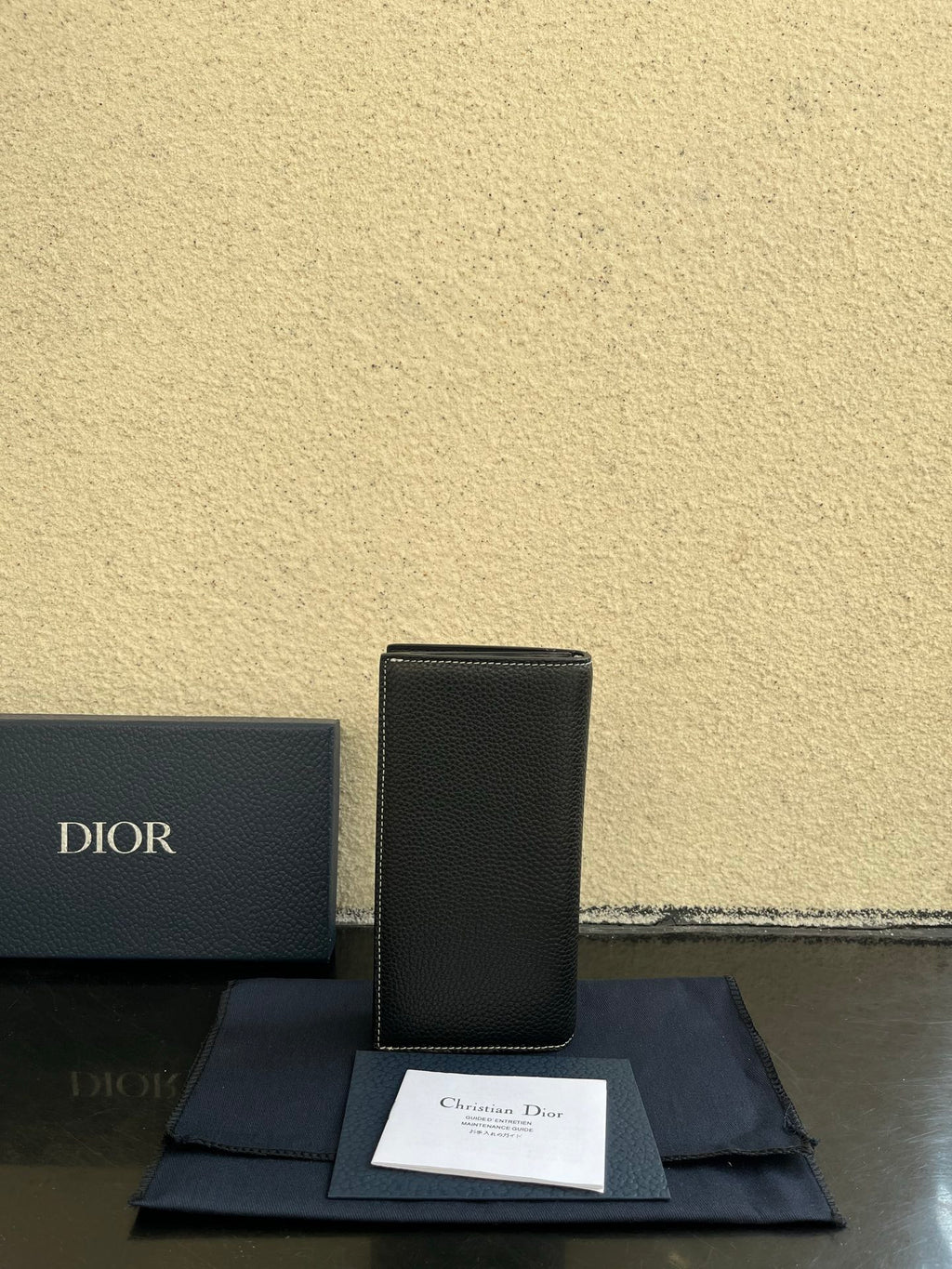 Small bag in dark gray textured leather, upright view with Dior logo on front
