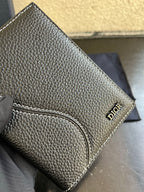 Dior small card holder bag in dark textured leather with stitched wristlet strap detail.