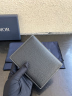 Dior card holder in dark textured leather with straight edge and logo on front.