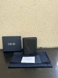 Dior card holder in dark textured leather with curved flap detail and Dior logo.