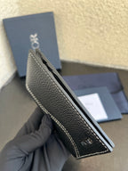 Small bag side view: dark leather wallet with contrast stitching and Dior branding