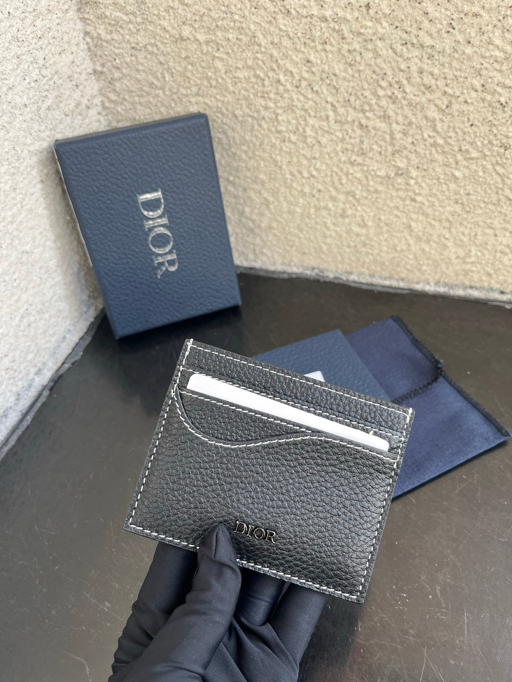 Dior card holder with front logo and silver top edge, textured dark leather