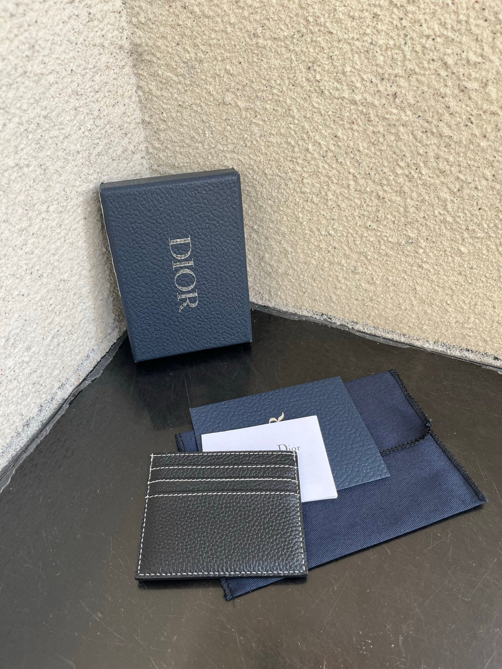 Dior small card holder with stitched border and logo, dark textured leather front