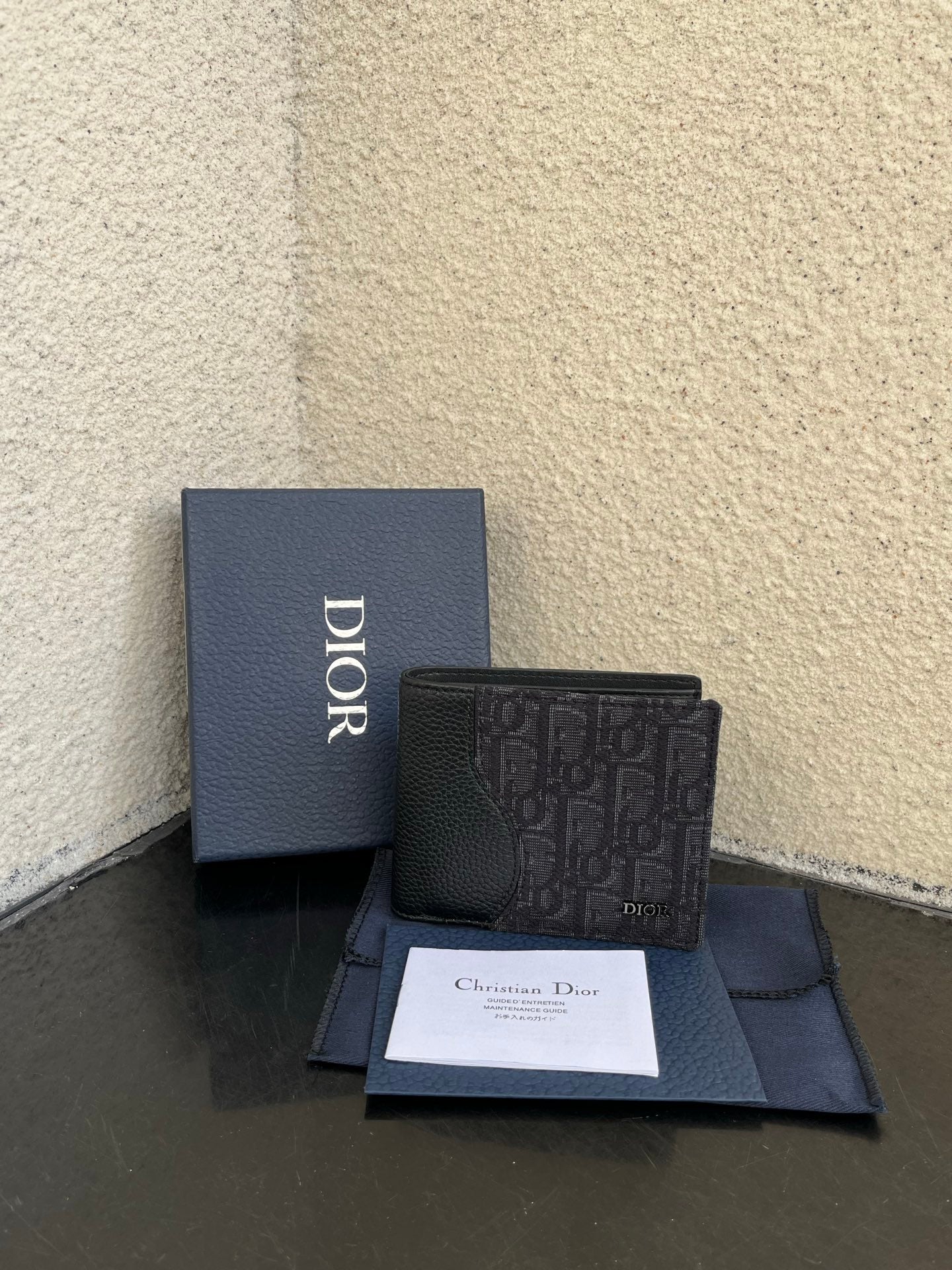 Dior small bag wallet in dark monogram canvas, front view with snap closure