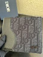 Dior small bag wallet close-up in dark monogram canvas with gold Dior emblem