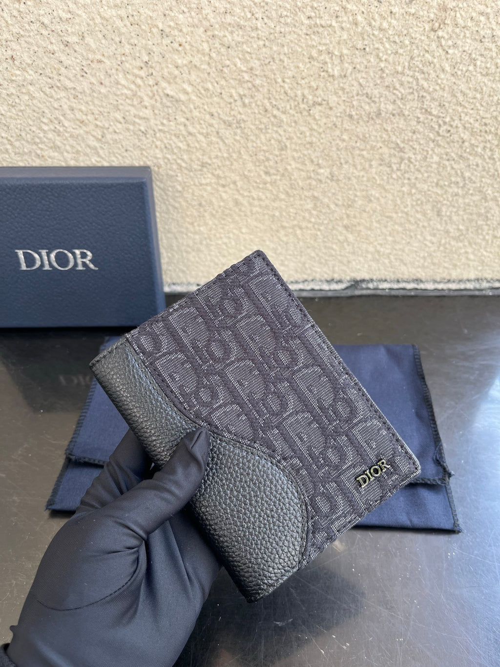 Dior small bag close-up with gray monogram fabric and grained leather front