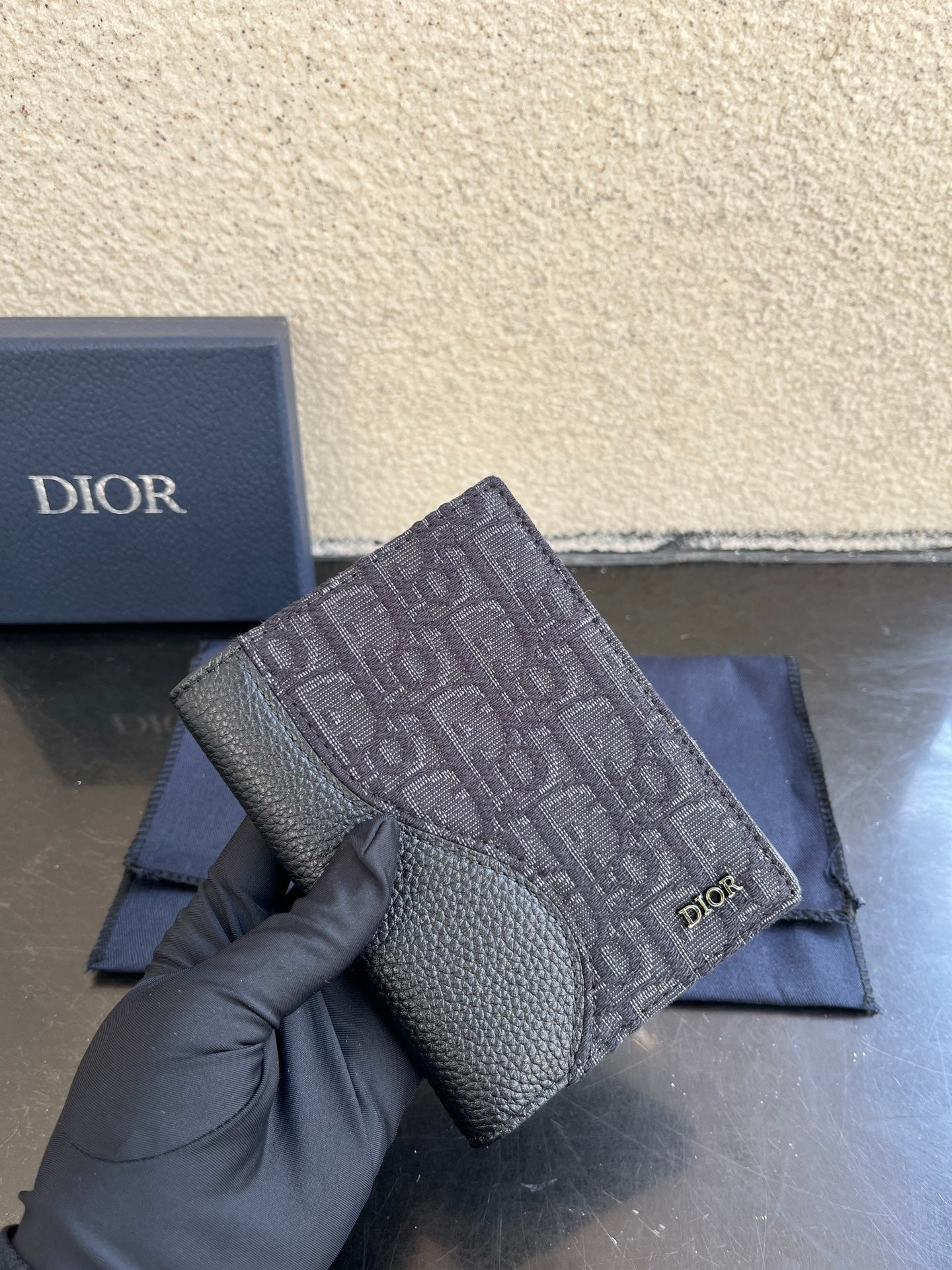Dior small bag close-up with gray monogram fabric and grained leather front