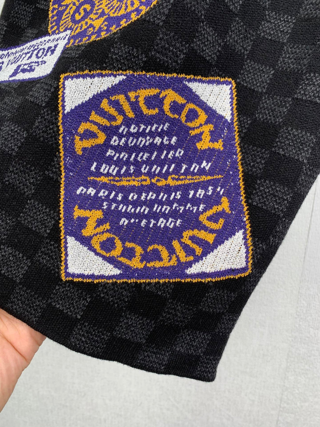 Louis Vuitton shorts with blue-and-gold logo patch on black check fabric
