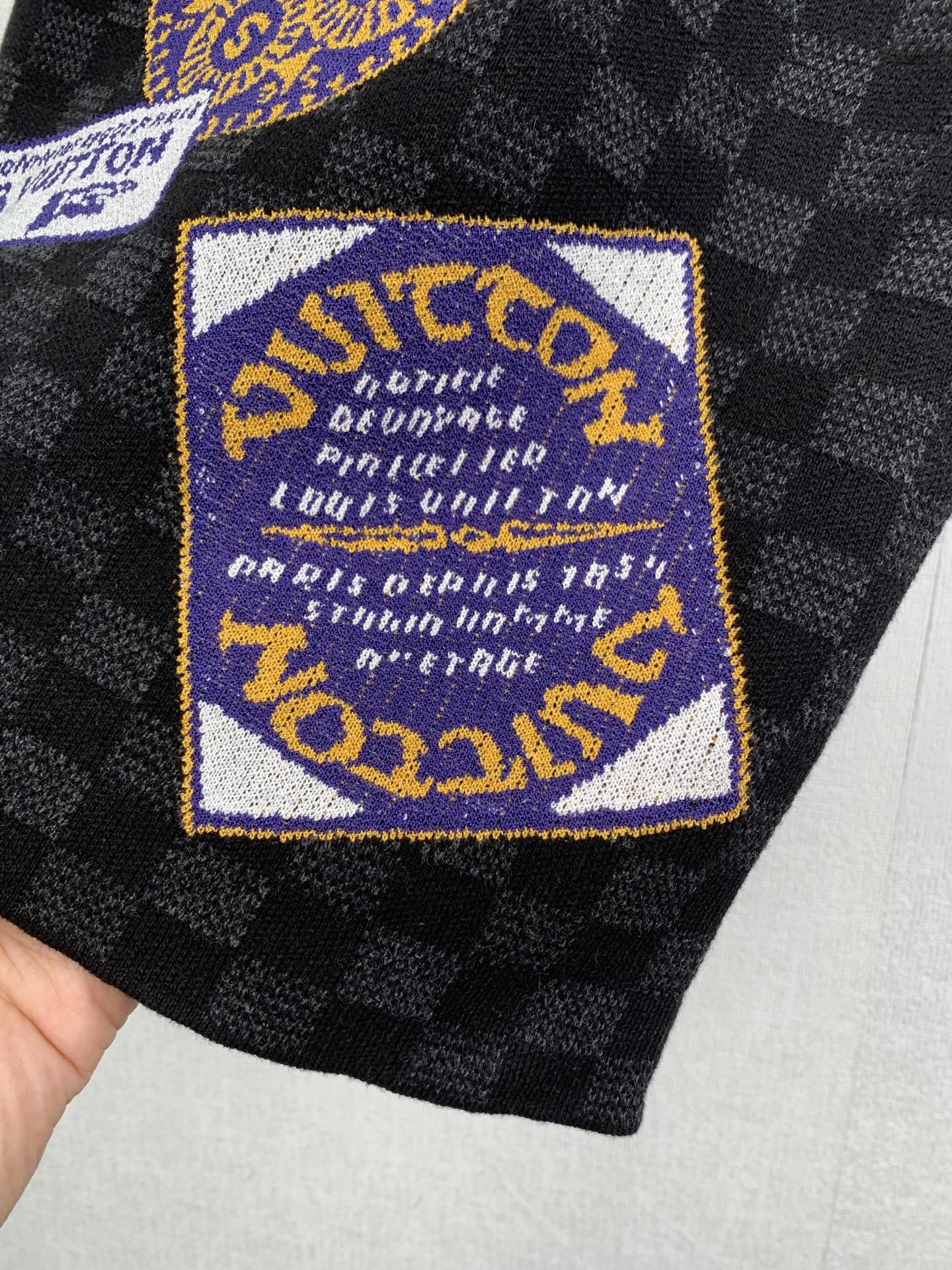 Louis Vuitton shorts with blue-and-gold logo patch on black check fabric