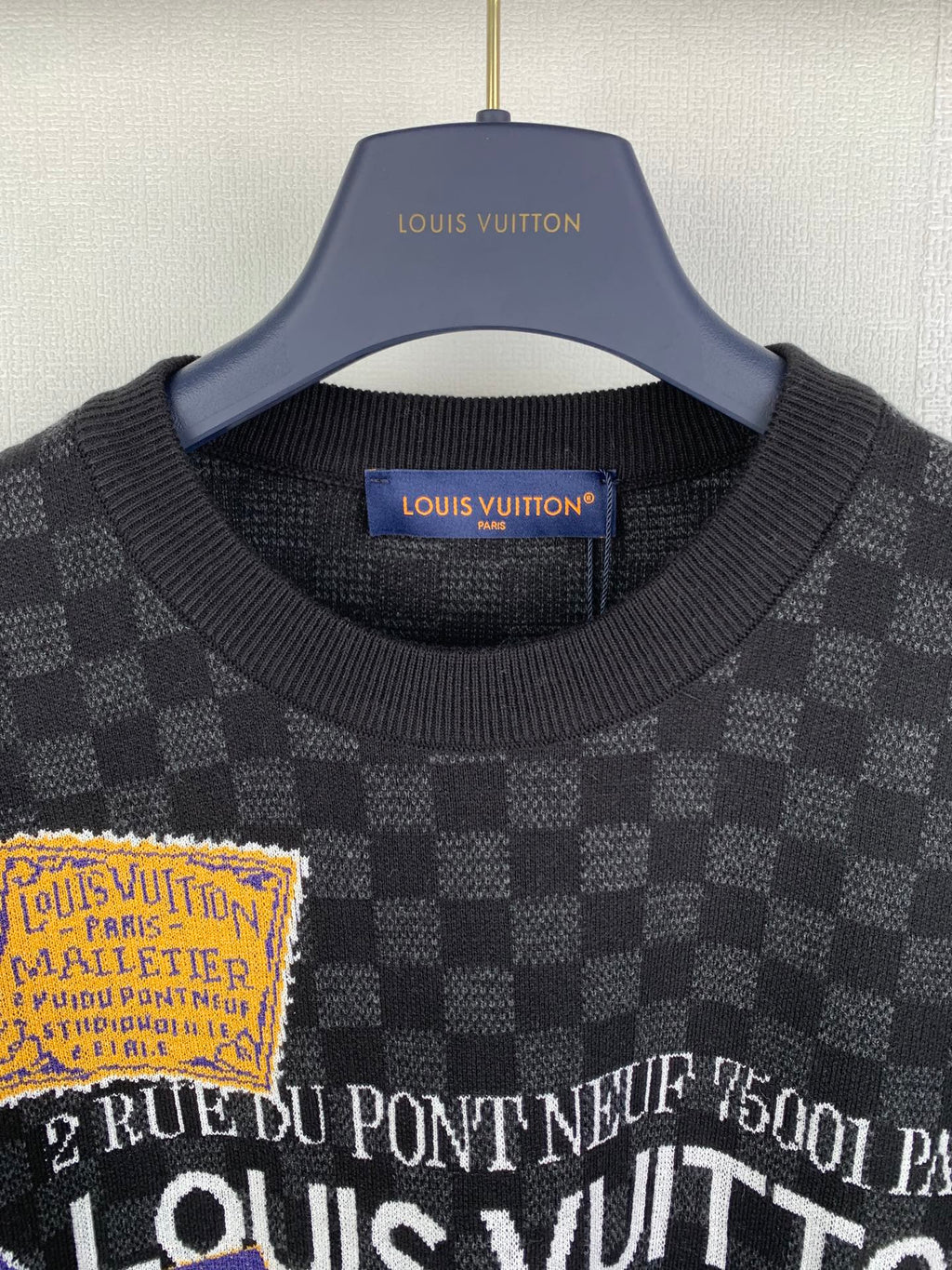 Black check short-sleeve T-shirt close-up of ribbed collar and printed text graphic