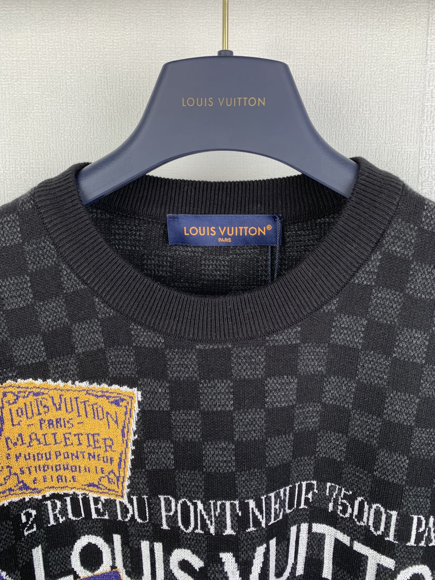 Black check short-sleeve T-shirt close-up of ribbed collar and printed text graphic
