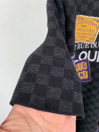 Black check short-sleeve T-shirt sleeve close-up with graphic patch at hem