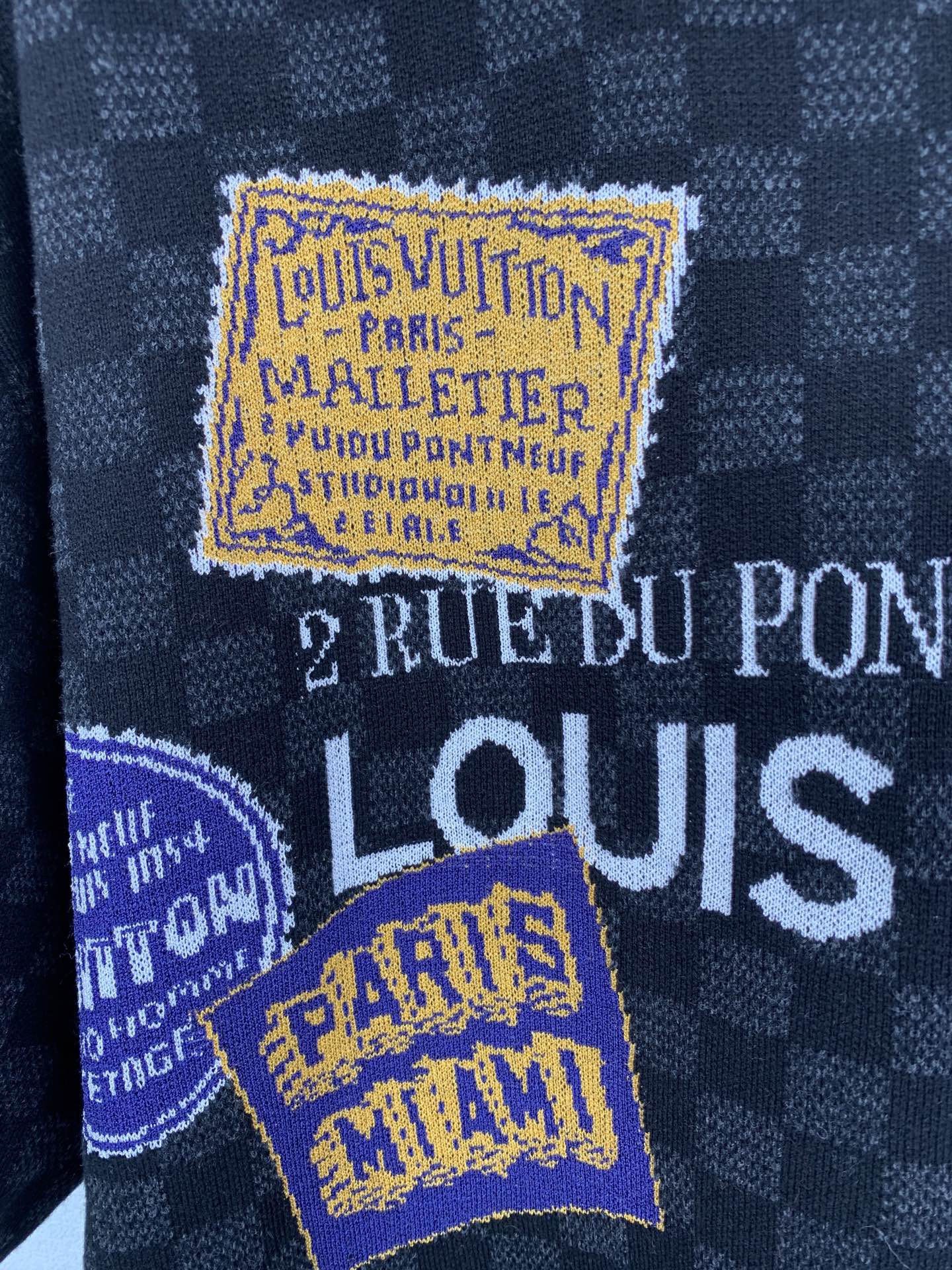 Black check short-sleeve T-shirt close-up of embroidered Louis Vuitton style labels